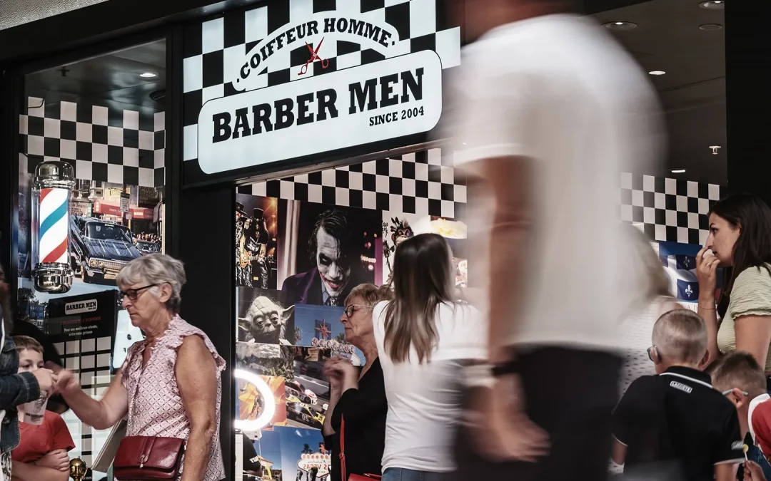Enseigne du salon BARBER MEN à Calais, avec effet de mouvement de passants devant.