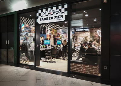 Salon BARBER MEN à Calais : façade, clients et enseigne lumineuse.