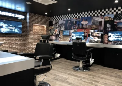 Intérieur du salon BARBER MEN à Istres : vue d'ensemble des postes de coiffage, de la vitrine et de l'enseigne.