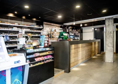 Vue de l’espace bar-tabac PMU / FDJ de L’Acte 08, combinant une zone de vente de jeux et de tabac à gauche et un bar moderne à droite.