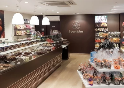 Intérieur élégant d’une boutique Léonidas, conçu par ERGONIUM, illustrant une réalisation de maîtrise d’œuvre pour un réseau franchisé.