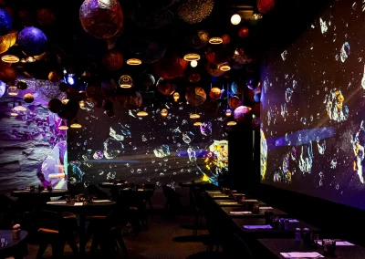 Salle du restaurant immersif Stellar avec ambiance cosmique et projections visuelles