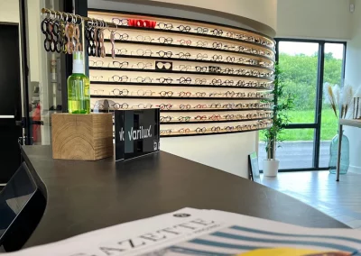 Mur incurvé avec étagères de lunettes dans la boutique Le Marchand de Lunettes à Saint-Avertin