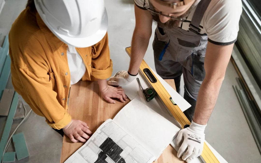 Professionnels de la maîtrise d’œuvre analysant des plans pour l’aménagement d’un local commercial