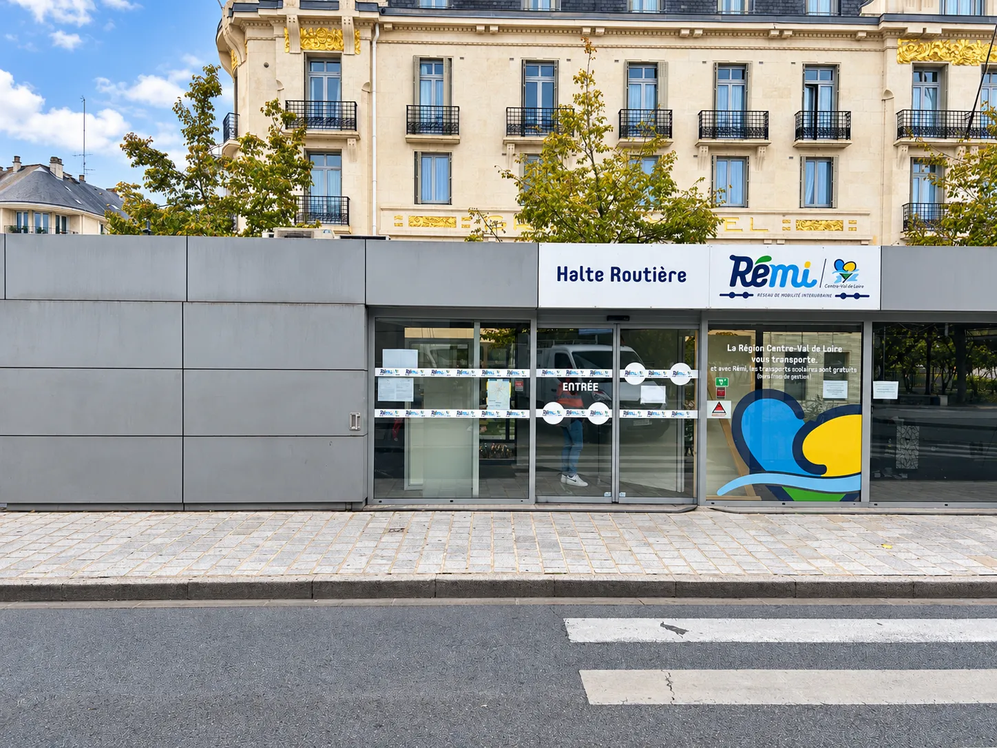 Façade du kiosque RÉMI de Tours avec son entrée vitrée, sa signalétique Halte Routière et ses panneaux métalliques.